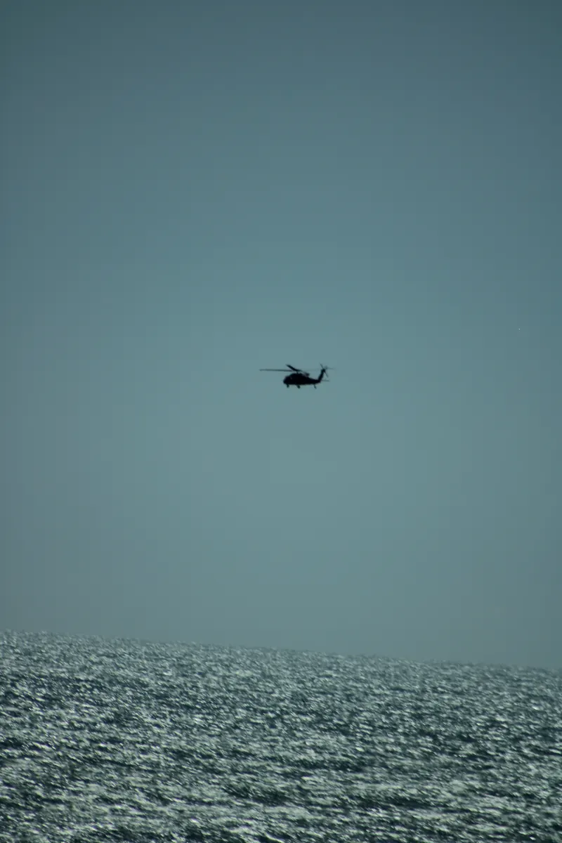 A helicopter flying low over the ocean