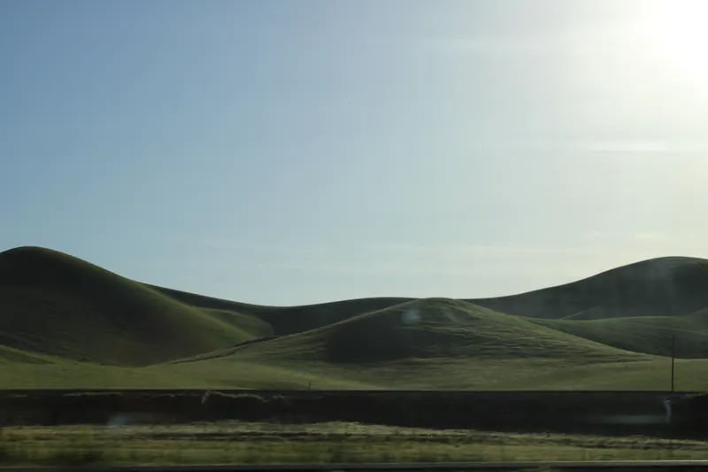 Green hills under a hazy sky