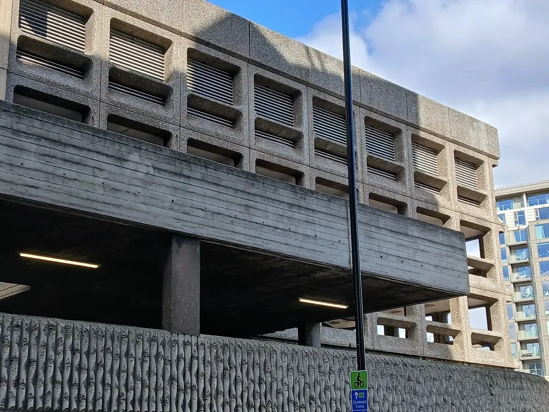 A concrete brutalist parking structure with ribbed walls