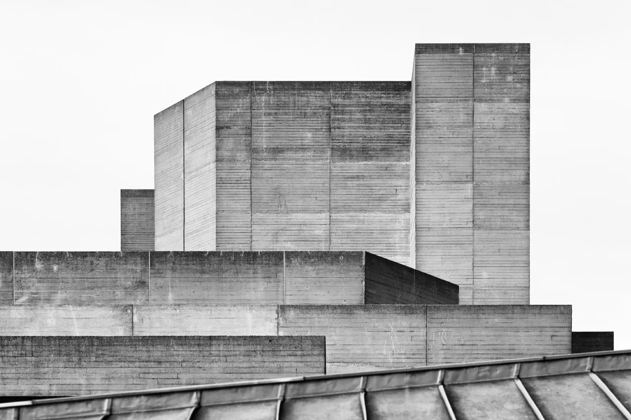 Stacked concrete volumes of a brutalist building against a white sky